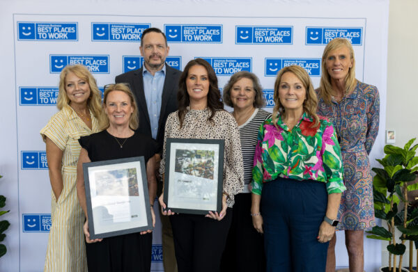 Full company team poses with awards.